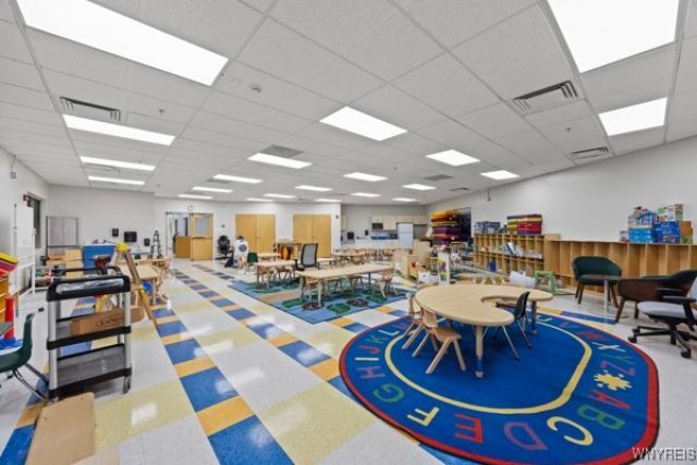 Early learning classroom at Cub Club Early Learning Center in Niagara Falls with tables, learning stations, and colorful rug